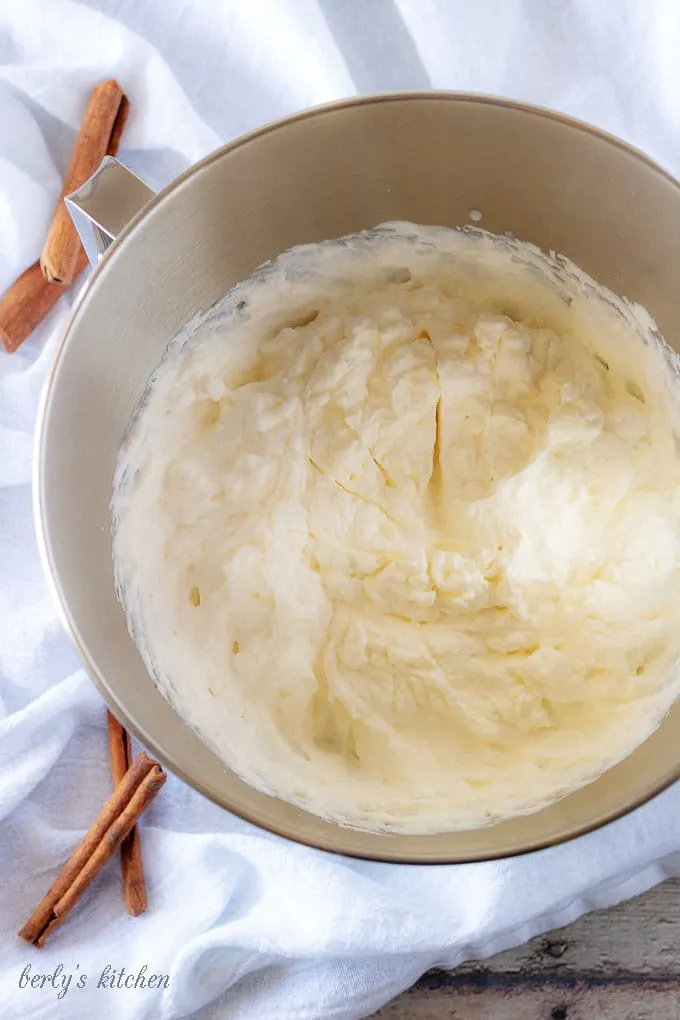 An aerial photo of the finished whipped cream in a mixing bowl showing stiff peaks of whipped cream.