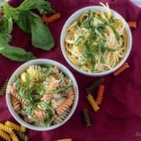 The finished lemon cream sauce served with tricolor rotini or spaghetti pasta in white bowls.