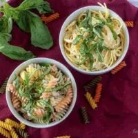 The finished lemon cream sauce served with tricolor rotini or spaghetti pasta in white bowls.