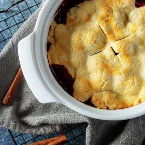 The finished berry cobbler, perfectly baked with a golden brown crust cooling just before being served.