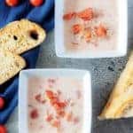 A top-down photo of the cream of tomato soup, served with toasted sourdough bread.
