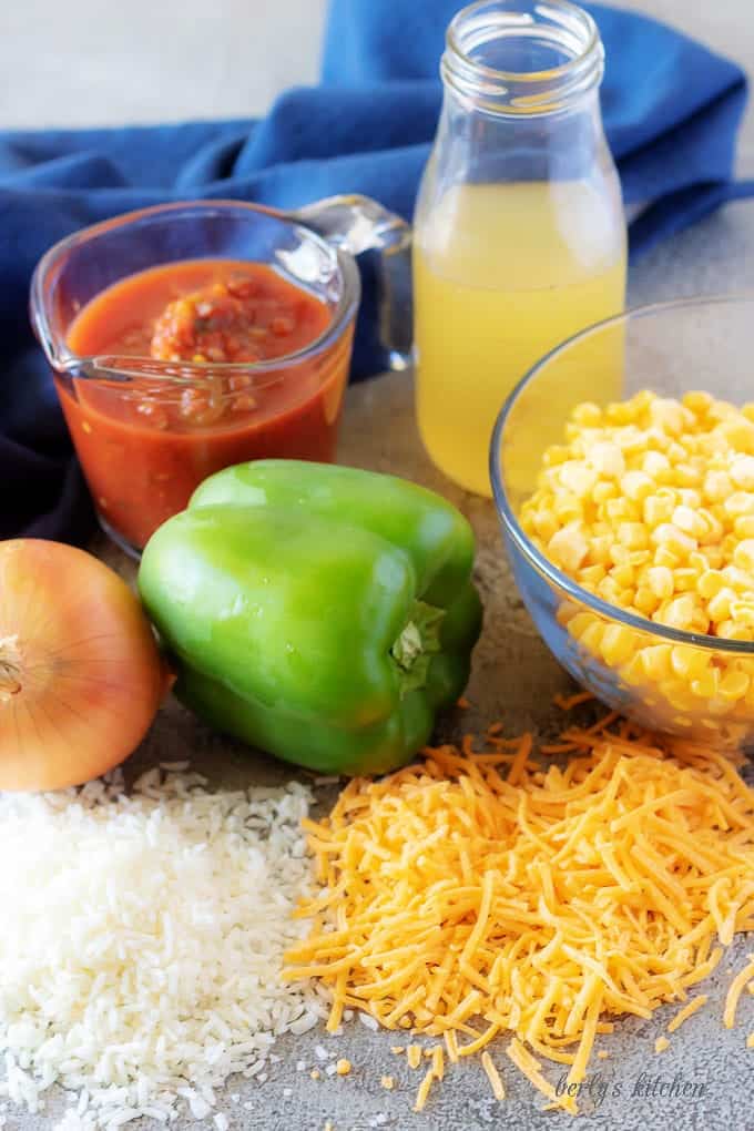 The mexican rice ingredients like peppers, onions, salsa, corn, and cheddar cheese.