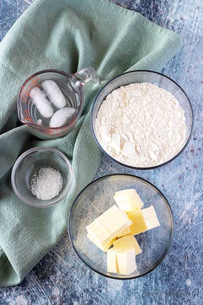 The homemade pie crust ingredients including flour, butter, salt, and iced water.
