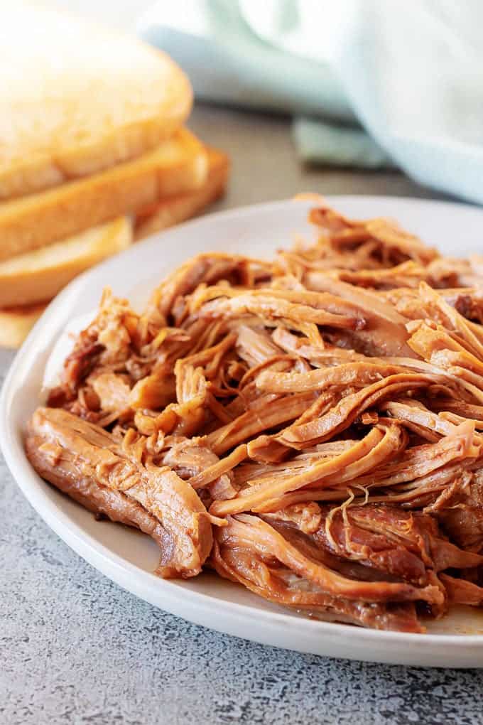 The cooked pulled pork sitting on a plate ready to assembled into a sandwich or bread of your choice.