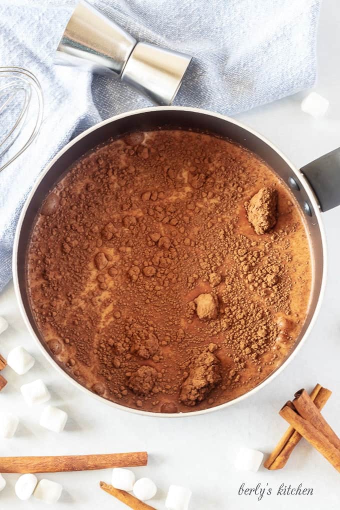 All of the spiked hot chocolate ingredients in a medium saucepan ready to be simmered.