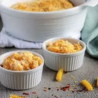 The finished baked macaroni and cheese served in white ramekins, topped with panko breadcrumbs.