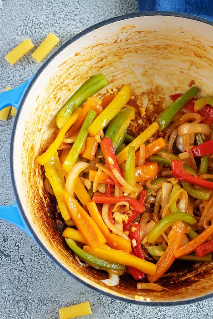 Arial view of bell peppers, onions, and garlic in a dutch oven.