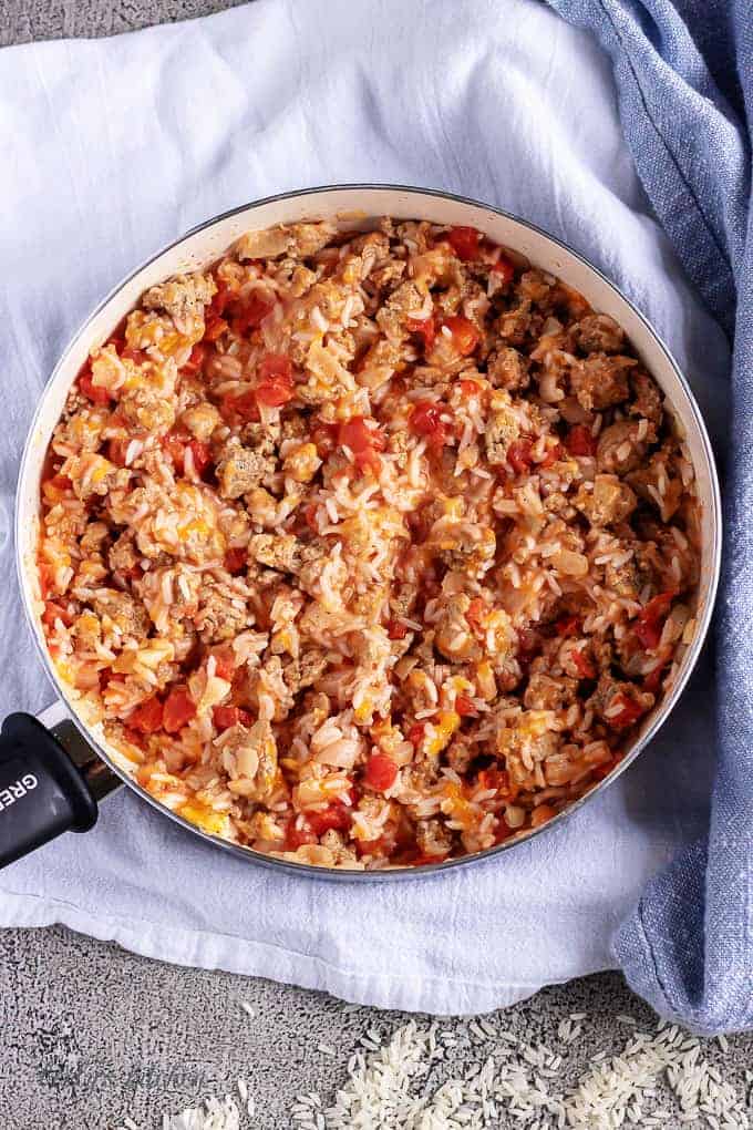 Arial view of cooked turkey, onions, tomatoes, rice, and cheese used in ground turkey stuffed peppers.