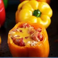 Cooked ground turkey stuffed peppers covered with melted cheese and tomatoes.