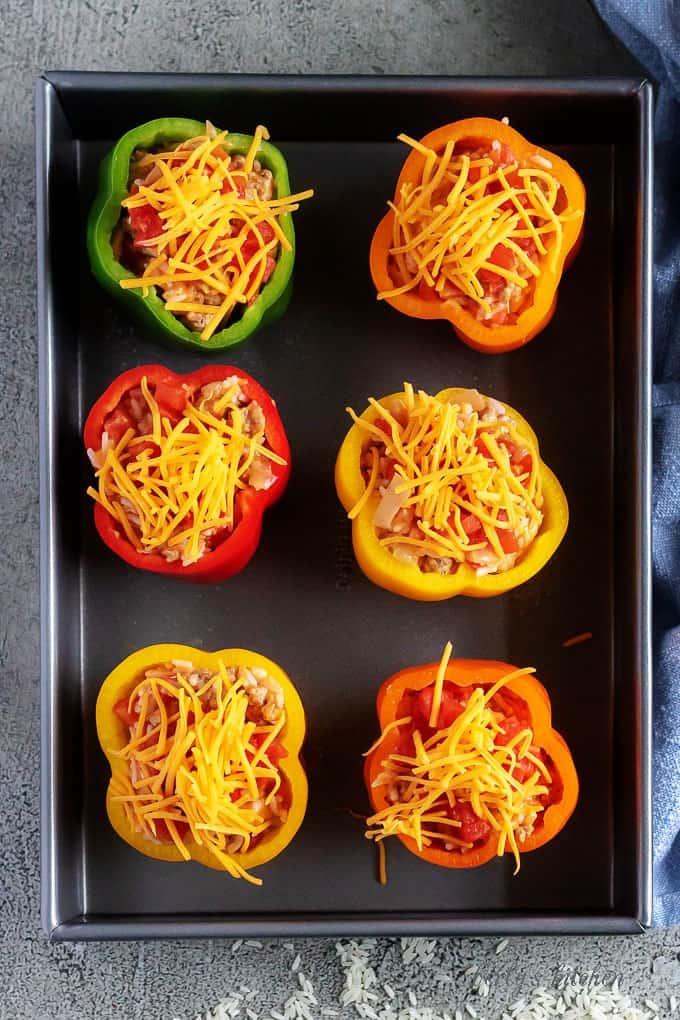 Arial view of uncooked prepared stuffed peppers in a baking dish.