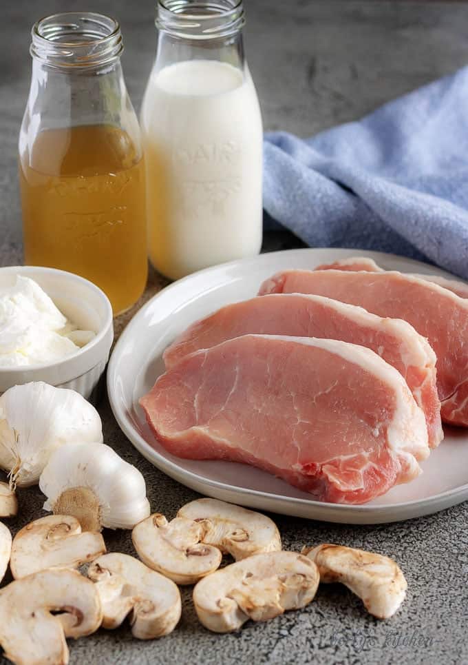 A photo of the instant pot pork chops ingredients like, fresh mushrooms, garlic, chicken broth, and sour cream.