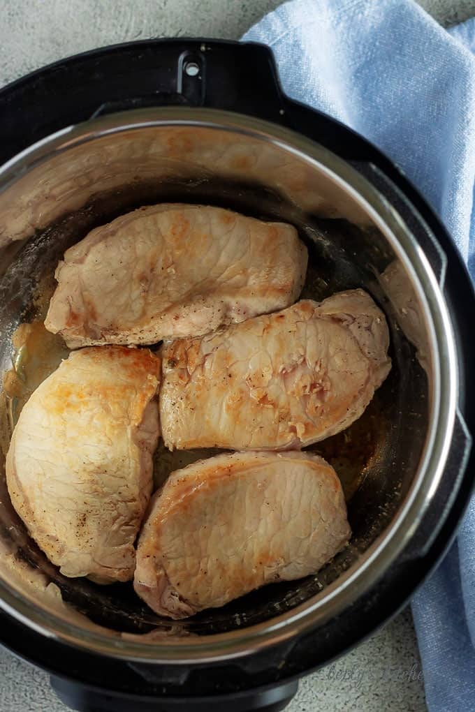 A top-down view of the seared pork chops in the instant pot.