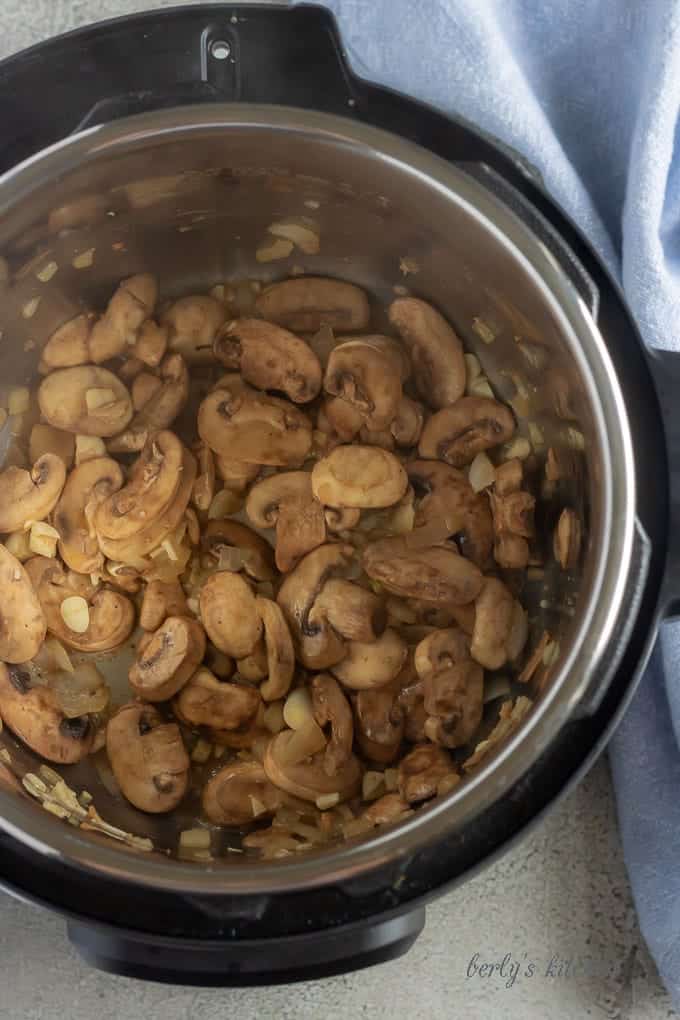 Another top-down picture of the mushrooms, onions, and garlic, cooking inside the Instant Pot.