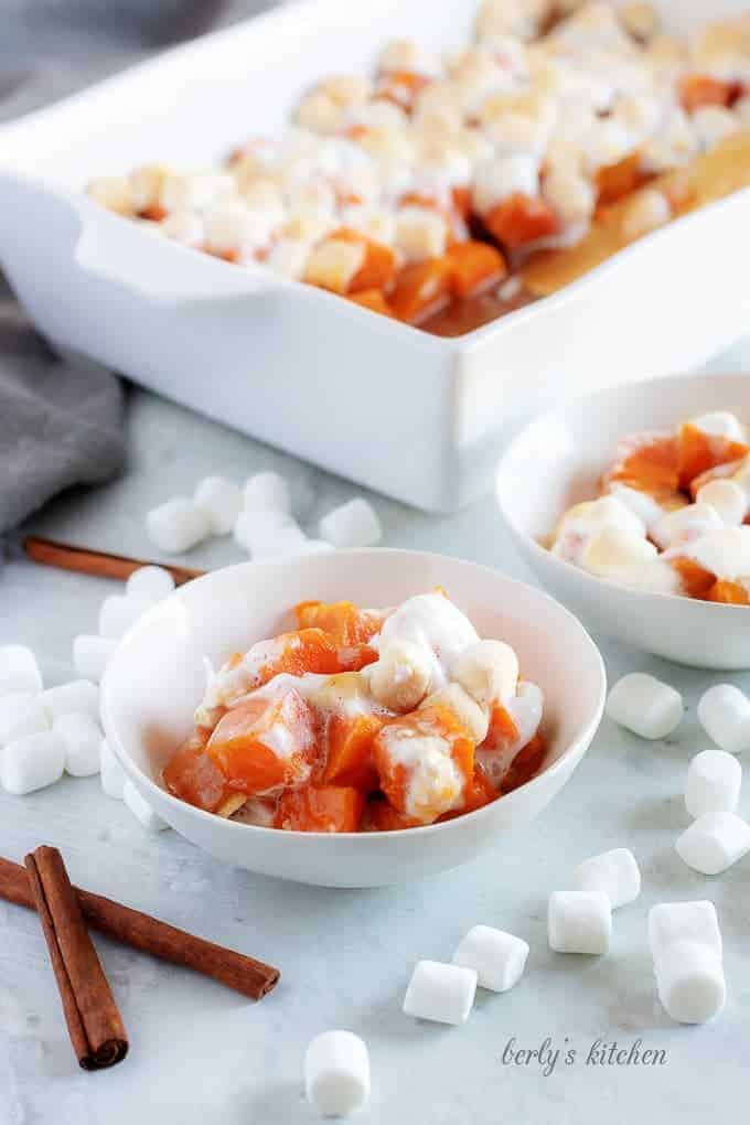 Candied sweet potatoes, sprinkled with marshmallows and served in little white bowls.