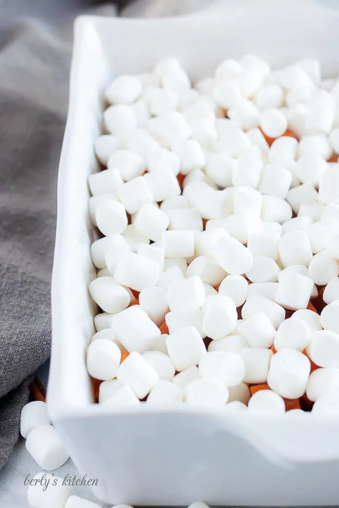 The sweet potatoes have been topped with mini-marshmallows and is now ready to bake.