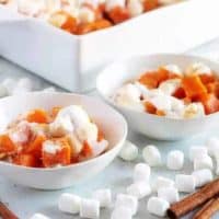The finished candied sweet potatoes, served in small bowls and topped with marshmallows.