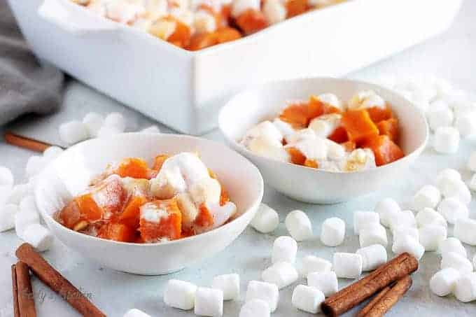 The finished candied sweet potatoes, served in small bowls and topped with marshmallows.