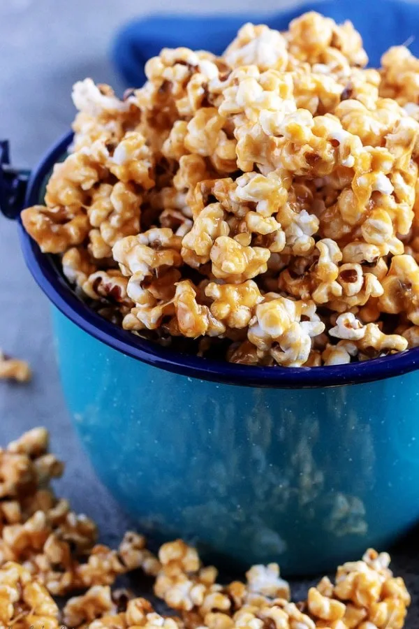A large picture of the finished caramel corn popcorn, served in a blue tin kettle.