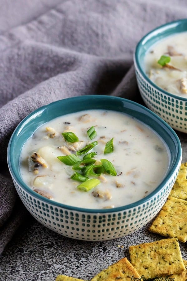 Two bowls of clam chowder in decorative bowls.