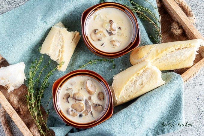 The finished easy mushroom soup served in two earthenware bowls with a side of bread.