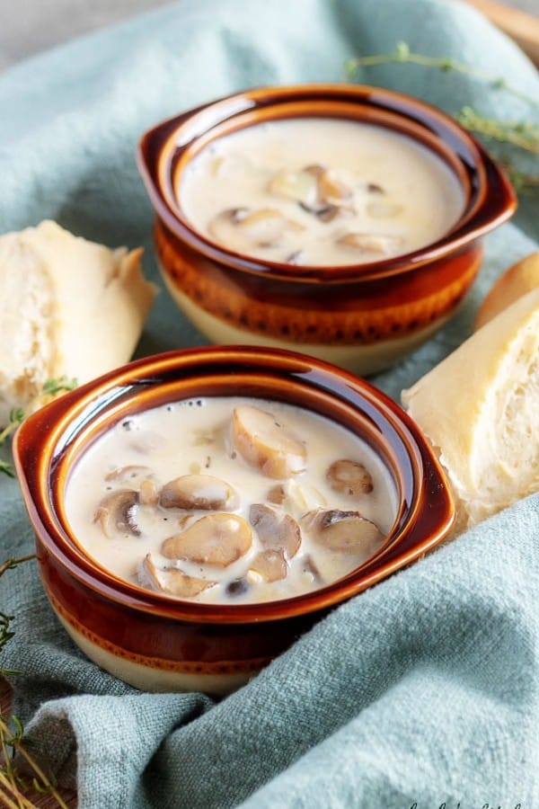 A large picture showing the easy mushroom soup in earthenware bowls served with crusty French bread.