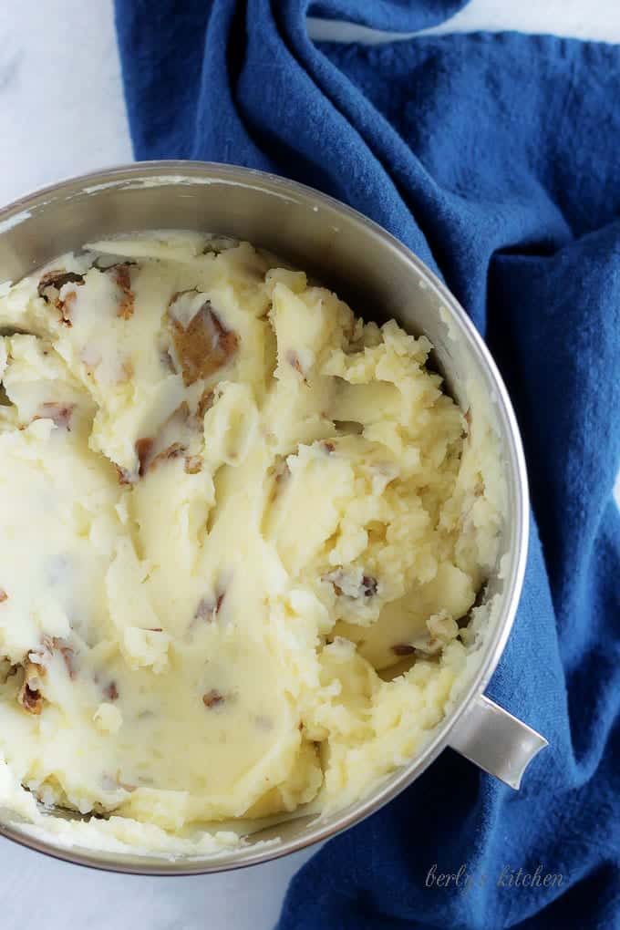 Another top=down photo of the mashed potatoes, mixed with butter and milk in a stand mixer bowl.