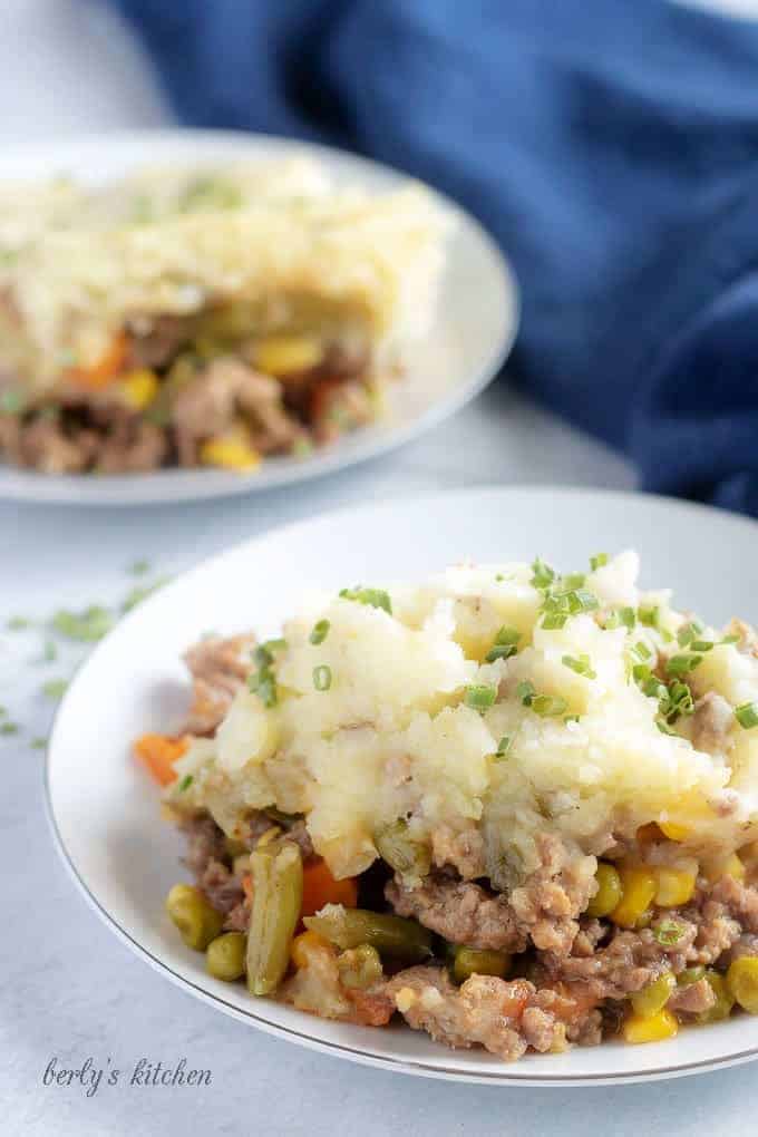 A large picture of the finished shepherd's pie on a plate, garnished with chives and ready to serve.