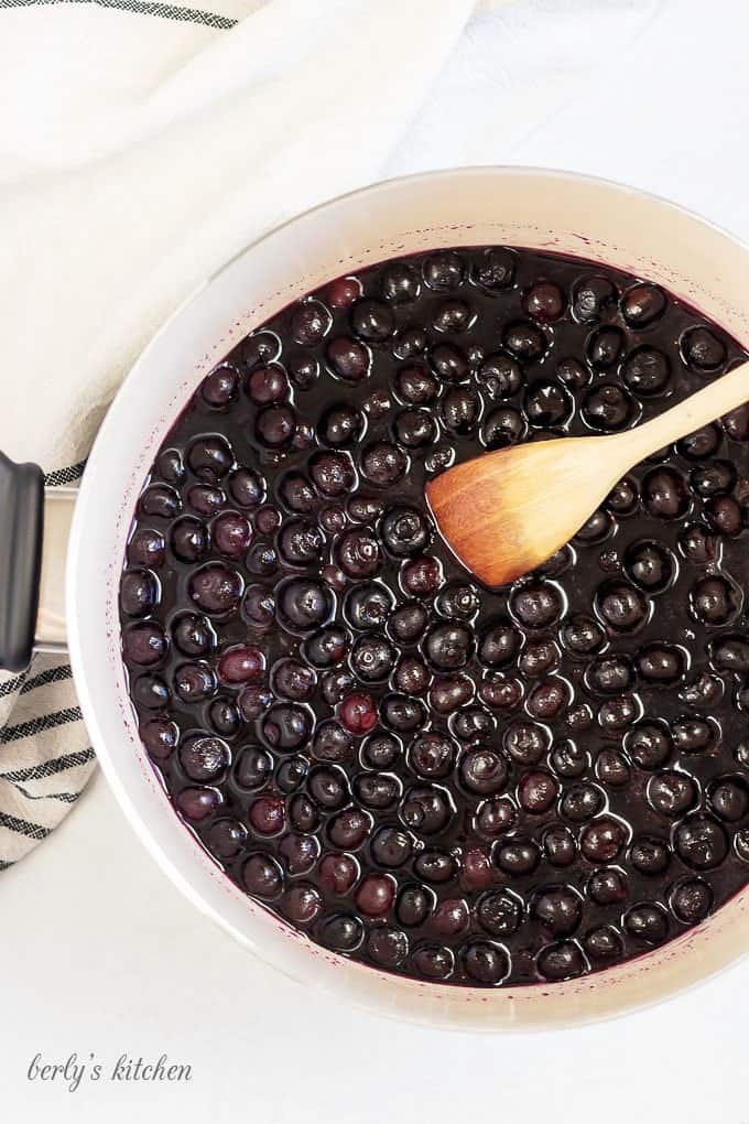 A top-down photo of the blueberries cooking in a large saucepan.