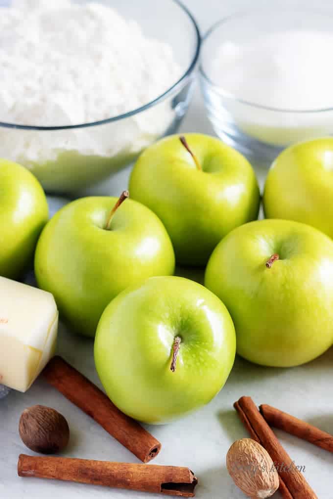 The Granny Smith apple pie ingredients like apples, cinnamon, and sugar.