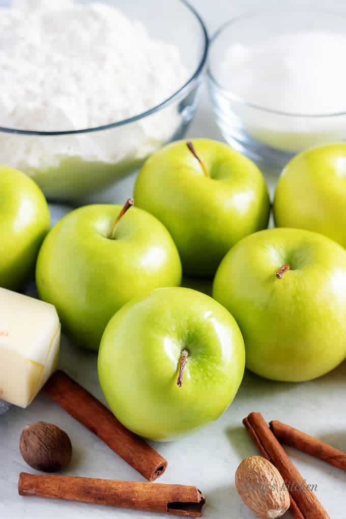 The granny smith apple pie ingredients like apples, cinnamon, and sugar.