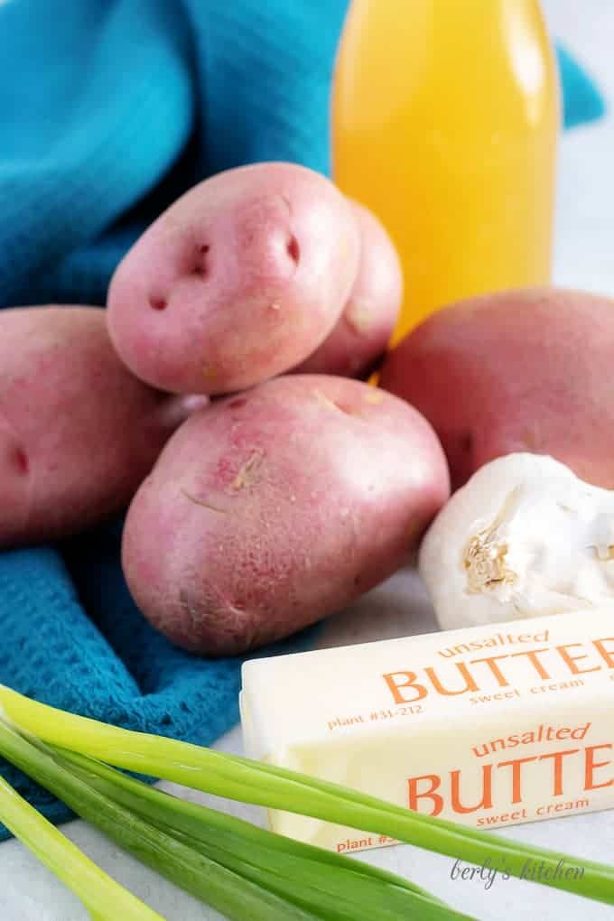 An ingredient photo showing the red potatoes, garlic, green onions, and butter.