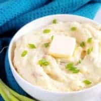 The final photo of the finished mashed red potatoes in a white serving bowl accented with a blue towel.