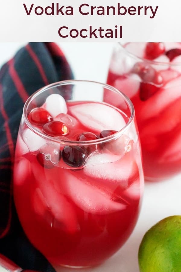 A large picture of the vodka cranberry cocktail served in two stemless wine glasses over ice, garnished with fresh cranberries.