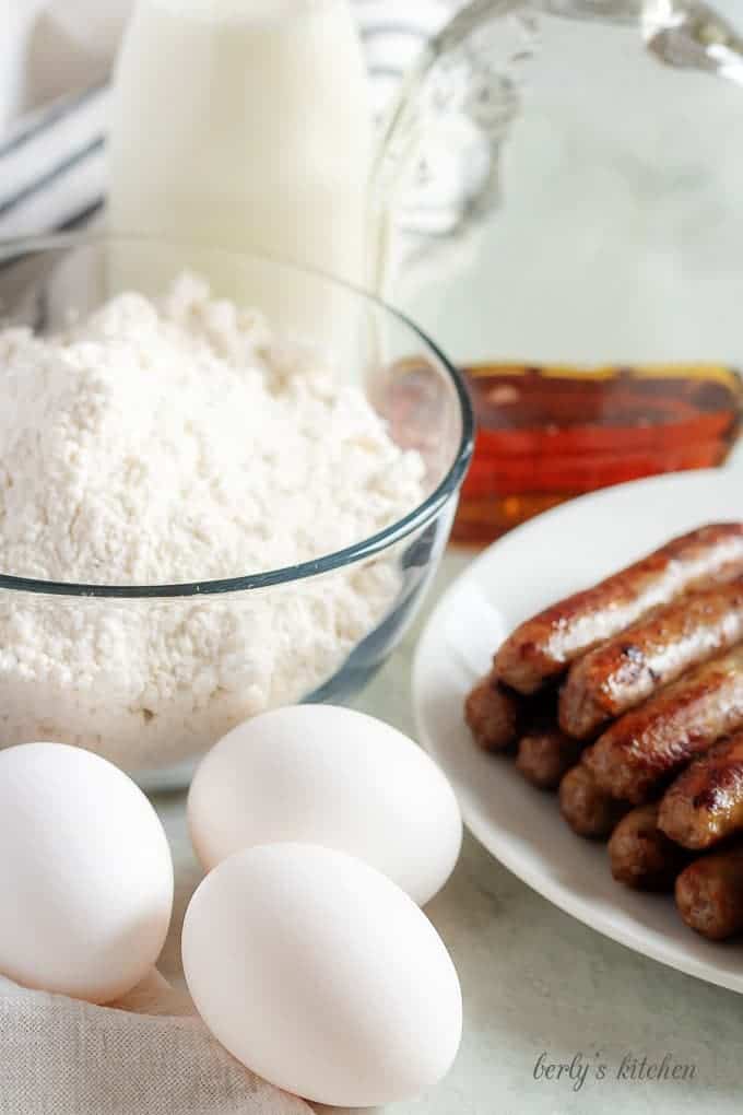 The breakfast taco ingredients like pancake mix, sausage, eggs, and milk.