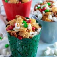 Christmas chex mix in three festive tins.