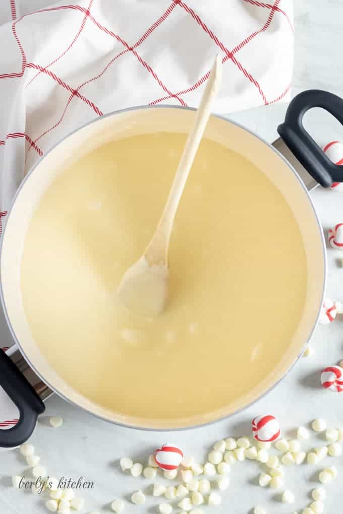 A top-down view of the white chocolate chips being melted in a large saucepan.