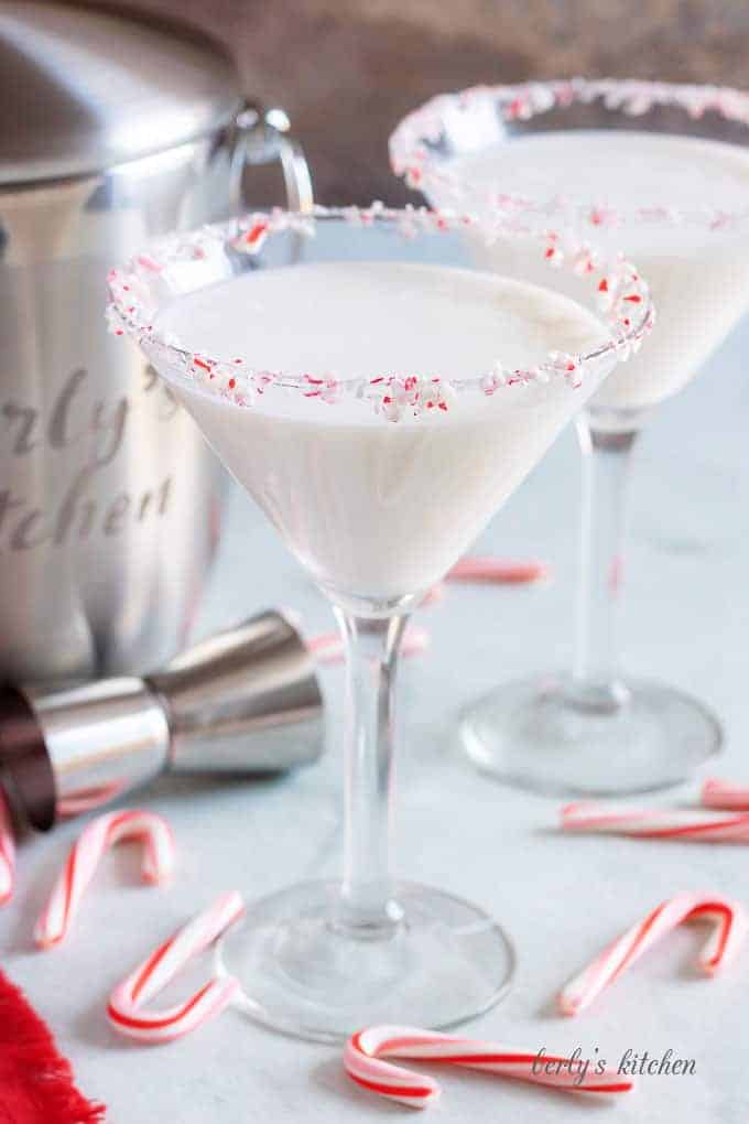A finished peppermint martini, rimmed with crushed candy cane pieces.