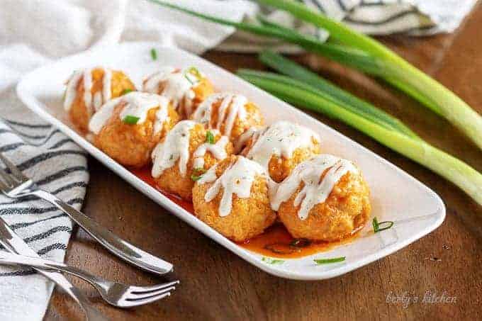 Slow cooker buffalo chicken meatballs with ranch dressing.