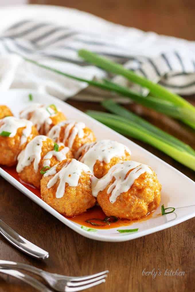 Buffalo Chicken Meatballs covered with ranch dressing.