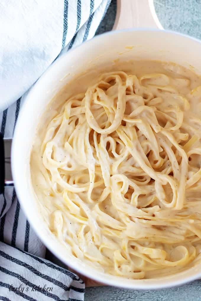 An aerial photo of the pasta being tossed with the alfredo sauce.