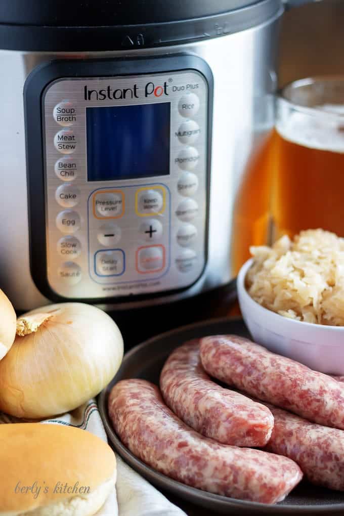 All the beer brats ingredients like beer, raw brats, and fresh onion,