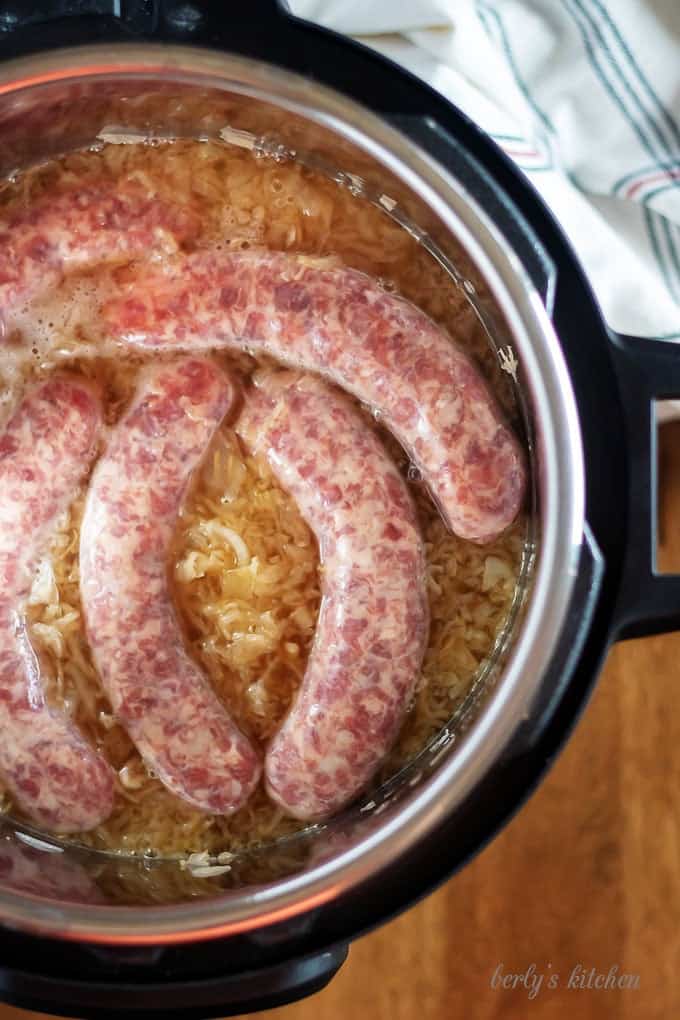 Top-down shot of the brats, in the pressure cooker, just before sealing.