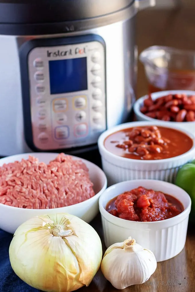 Instant Pot chili recipe ingredients like beef, tomatoes, onions, and beans.