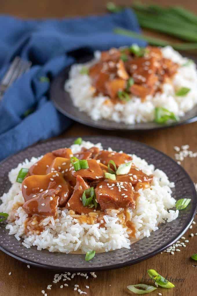 The honey garlic chicken, over rice, garnished with sliced green onions.