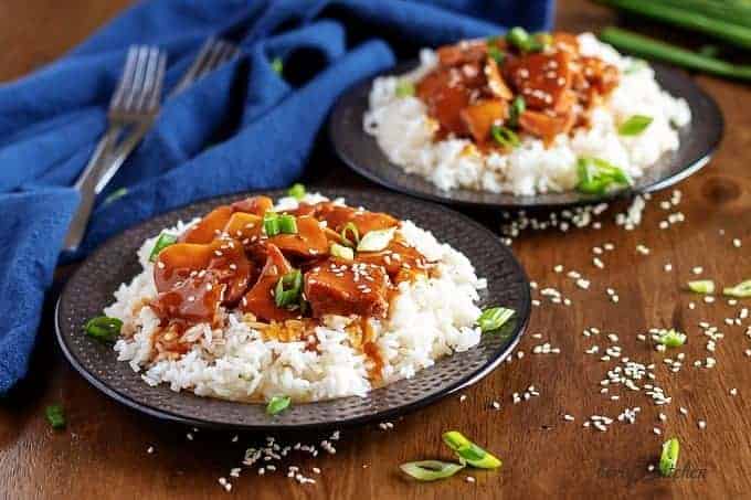 Two plates of honey garlic chicken served over white rice.
