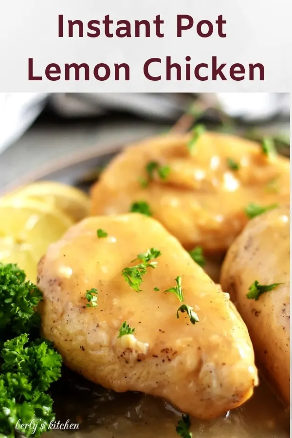 Lemon chicken breasts, garnished with lemon slices and parsley, topped with sauce.
