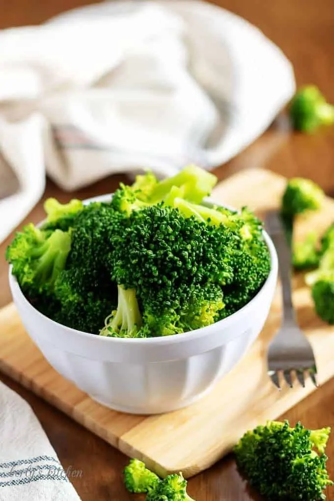 A picture of the Instant Pot Steamed Broccoli in a bowl on a cutting board.