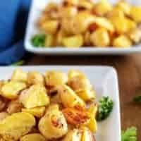 Two bowls of garnished ranch potatoes, ready to be served.