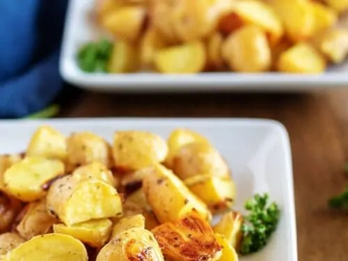 Two bowls of garnished ranch potatoes, ready to be served.