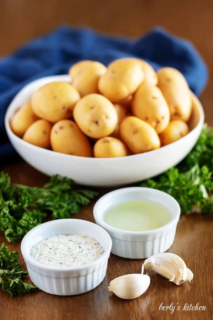 All 4 ingredients for the recipe, potatoes, garlic, oil, and ranch seasoning.